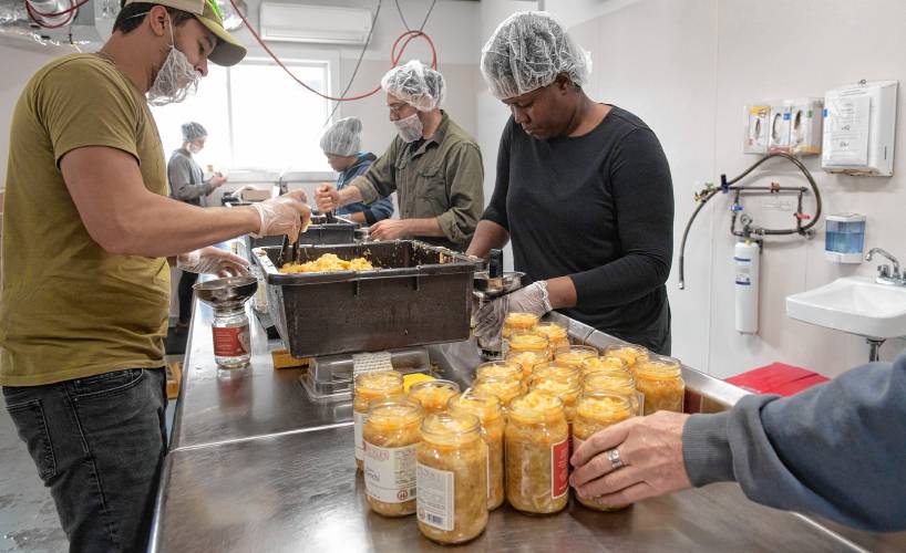 Shane Carroll, Gillis MacDougall, Marie Maude Joseph, Victor Signore, Katie Desi, and Andy VanAssche package kimchi at Real Pickles in Greenfield.