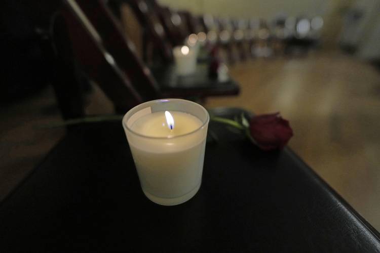 Thirteen chairs are empty with candles and roses to remember the 25th anniversary of the Columbine High School mass shooting, Friday, April 19, 2024, in Denver.