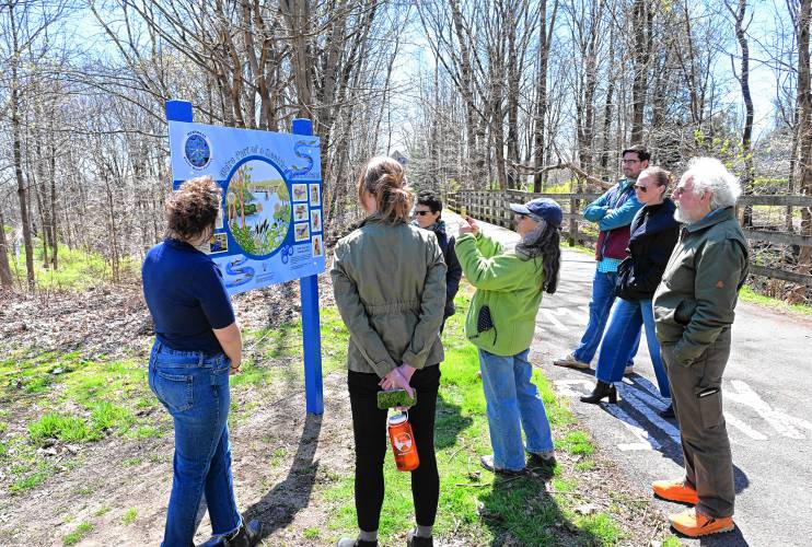 People check out the new sign near the Montague Clean Water Facility marking an entrance to the bike path on Greenfield Road in Montague.