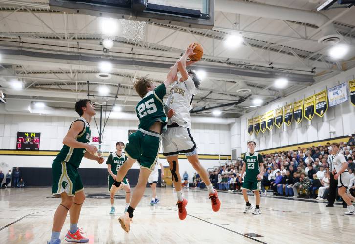 Pioneer’s Kurt Redeker (3) drives to the hoop against Ware defender Justin Grout (25) in the third quarter of the MIAA Division 5 quarterfinal Friday night in Northfield.