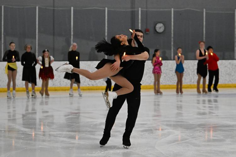 Guest skaters Michela Melillo and Karl Schapfel skate with electric candles during the finale at the ice rink at Deerfield Academy during the New England West Skating Show on Saturday. 