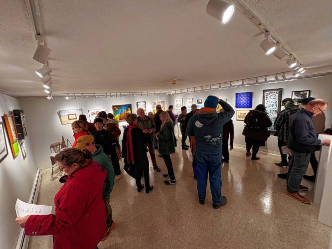 Artists, friends and family members explore the “FORWARD” exhibit at Artspace Community Arts Center in Greenfield during Friday’s opening reception.
