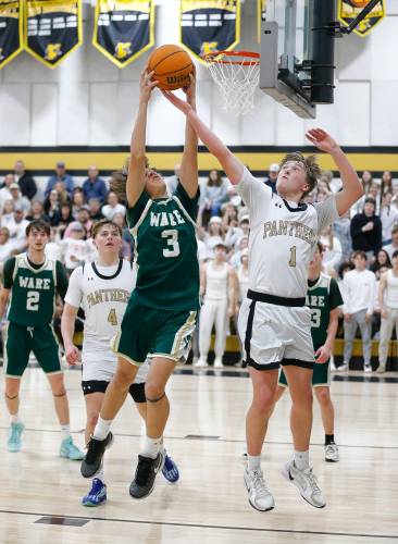 Pioneer’s Ben Werner (1) fights for a rebound against Ware defender Jason Mumper (3) in the fourth quarter of the MIAA Division 5 quarterfinal Friday night in Northfield.