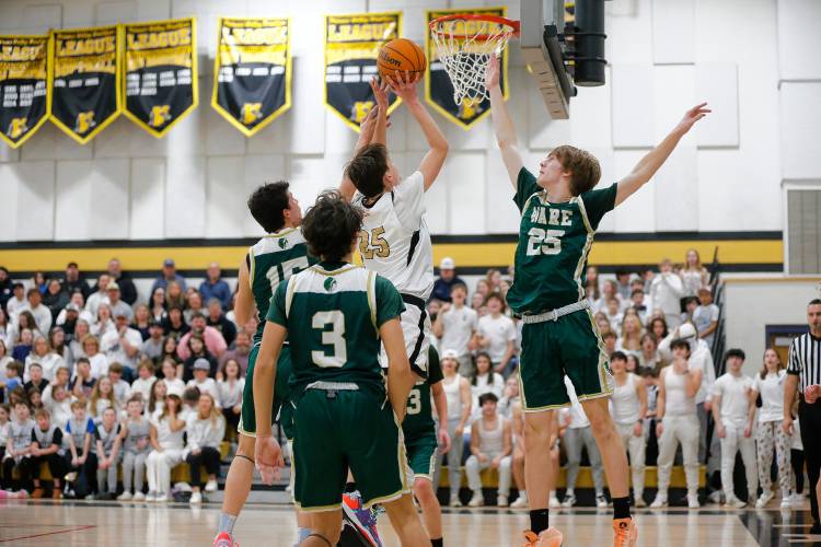 Pioneer’s Will Glazier (25) drives to the hoop against Ware in the fourth quarter of the MIAA Division 5 quarterfinal Friday night in Northfield.
