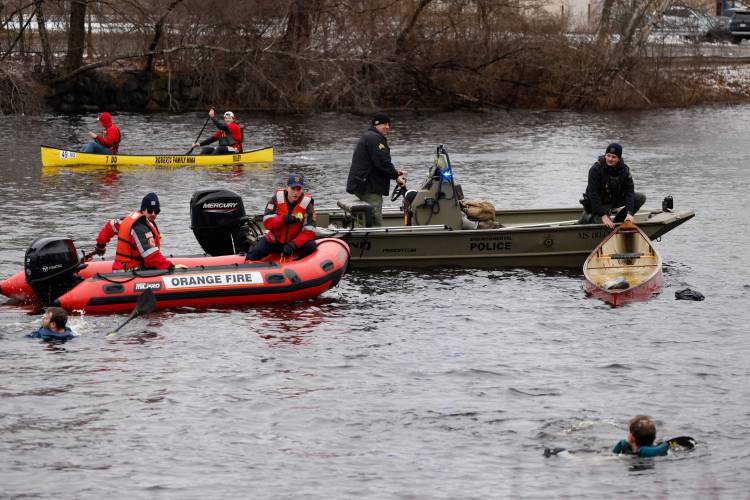 Eben Cross and Aaron Baskerville take a swim as rescue teams recover their canoe during the 60th annual River Rat Race from Athol to Orange on Saturday.