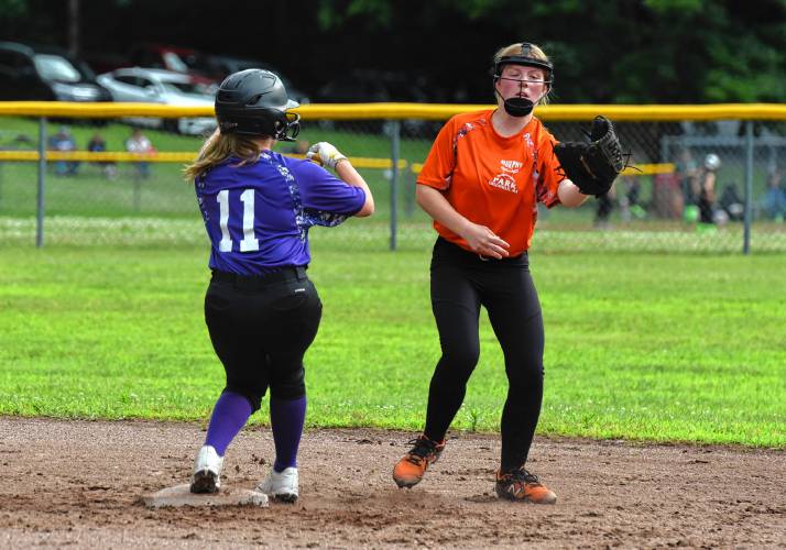 Menace’s Caroline Payson, right, catches the throw while the Defenders’ Kaelyn Chabot (11) arrives safely on a stolen base attempt during a Franklin County Summer Softball League contest on Monday night at Murphy Park in Greenfield.