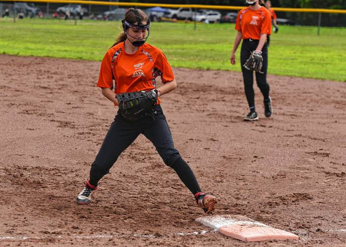 Menace first baseman Alexa Peters touches the bag for an out against the Defenders during a Franklin County Summer Softball League contest on Monday night at Murphy Park in Greenfield.