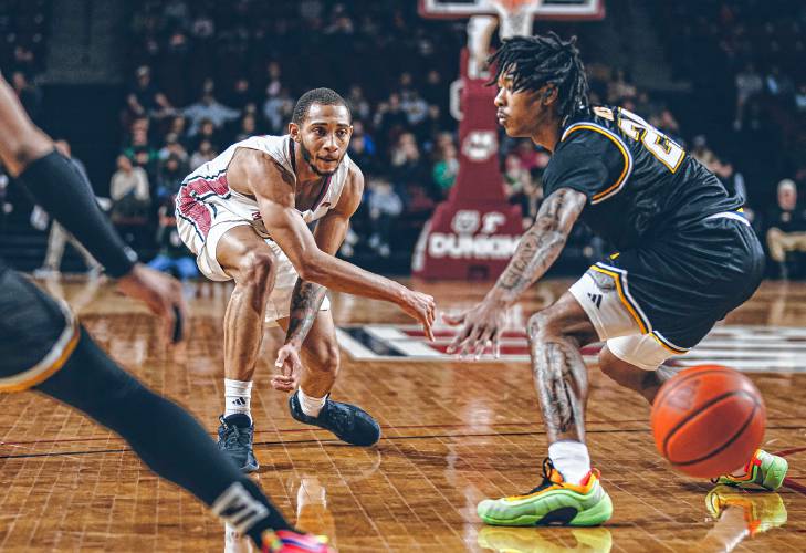 UMass guard Rahsool Diggins (7) bends down to make a bounce pass into the paint during the Minutemen’s 82-60 win over La Salle on Sunday night at Mullins Center in Amherst.