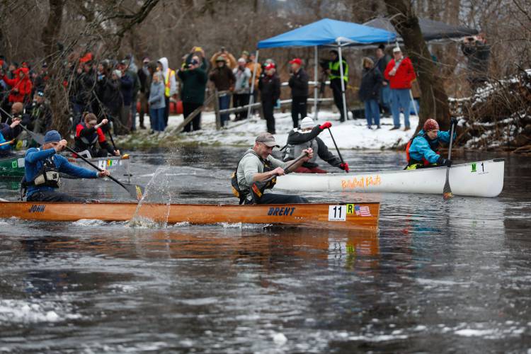 Brent Lyesiuk and John Berry in the No. 11 boat paddle to the front of the pack alongside Karen Pleasant and Ken Oshowski in the No. 1 boat at the start of the 60th annual River Rat Race from Athol to Orange on Saturday.
