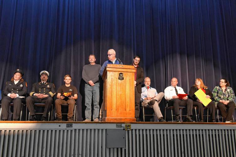 Ralph C. Mahar Regional School student Joel Wilkey, third from left, is honored for his quick thinking during a chimney fire by town and state officials during an assembly at the school on Friday morning. 