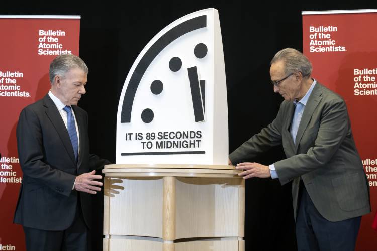 Former Colombian President Juan Manuel Santos, left, and Bulletin of the Atomic Scientists member Robert Socolow reveal the “Doomsday Clock,” set at 89 seconds to midnight, during a news conference at the United States Institute of Peace, Tuesday, in Washington.
