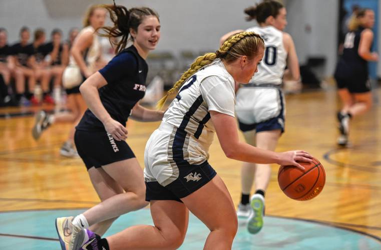 Frankiln Tech’s Madyson Lynde (22) dribbles while defended by Frontier’s Addie Hduring the visiting Redhawks’ victory on Friday night in Turners Falls.