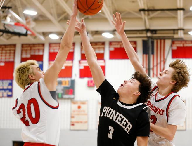 Frontier’s Sasha Dragicevich (20), left, blocks a shot from Pioneer’s Kurt Redeker (3) in the first quarter Friday night at Goodnow Gymnasium in South Deerfield.
