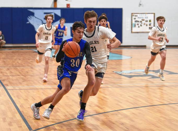 Turners Falls’ Dylen Richardson is defended by Franklin Tech’s Robert Belval during the visiting Thunder’s 55-35 Hampshire League North victory on Tuesday night in Turners Falls.