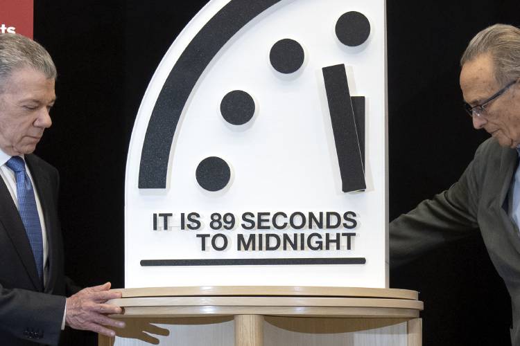 Former Colombian President Juan Manuel Santos, left, and Bulletin of the Atomic Scientists member Robert Socolow reveal the “Doomsday Clock,” set at 89 seconds to midnight, during a news conference at the United States Institute of Peace, Tuesday, in Washington. 
