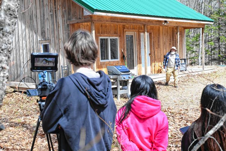 Actor Kyle D. King walks out of a cabin as Emerson College students make a short film at Salamander Hollow Healing Habitat in Warwick.