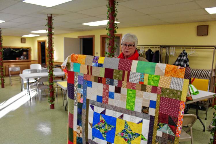 Heath resident Eileen Lively holds up a quilt she made to send to hurricane victims in North Carolina.