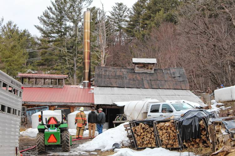 Firefighters pack up gear after extinguishing a fire at Hager’s Farm on Merrifield Lane in Colrain on Wednesday.