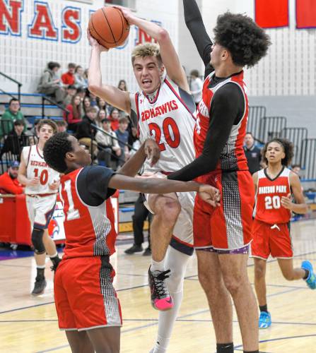 Frontier’s Sasha Dragicevich (20) splits a pair of Madison Park Tech defenders during the Redhawks’ 81-46 victory in the MIAA Division 4 preliminary round on Tuesday night at Goodnow Gymnasium in South Deerfield.
