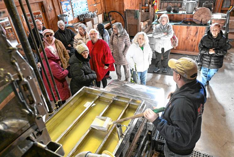 Doug Bennett of Williams Farm Sugarhouse in Deerfield gives a tour of the evaporator room on Friday to a group from Prospect, Connecticut.