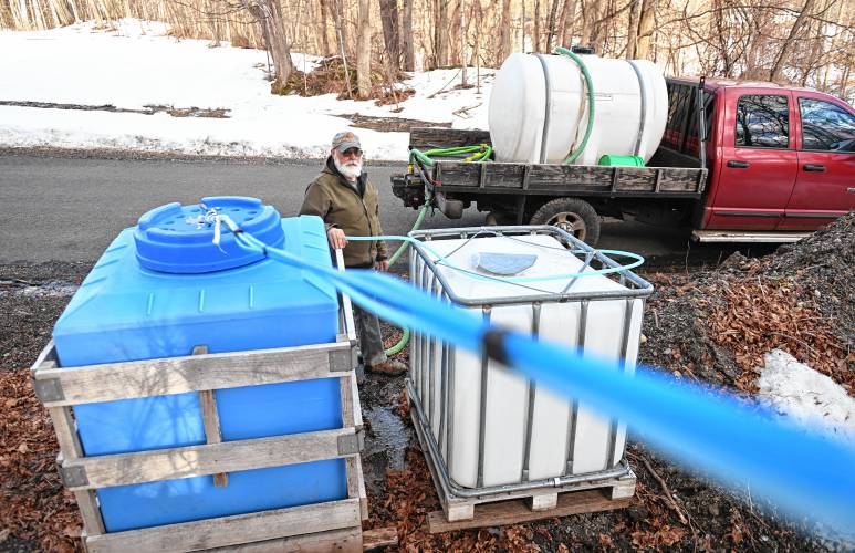 Howard Boyden of Boyden Brothers Maple in Conway pumps sap from these containers into his truck on Friday. Boyden has about 350 taps on this tap line draining a hillside in Conway.