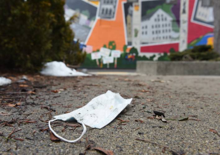 A discarded blue mask lies on the ground at Veterans Mall in Greenfield.