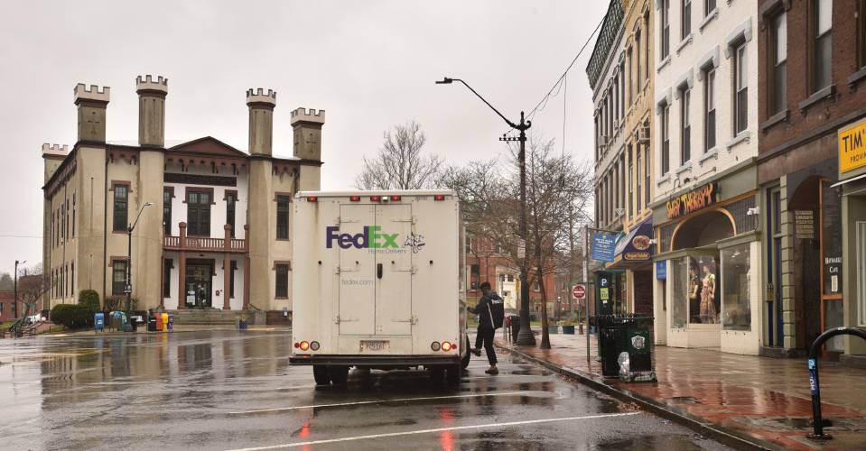 A FedEx driver returning to his truck is the only activity on Main Street in Northampton at 12:30 p.m. on Monday, April 13, 2020.