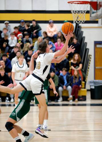 Pioneer’s Brayden Thayer drives to the hoop against Greenfield in the fourth quarter Monday in Northfield.