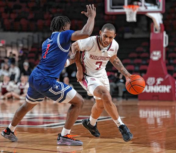 UMass senior guard Rahsool Diggins (7) drives against Richmond’s Mikkel Tyne in a game earlier this season at Mullins Center in Amherst.