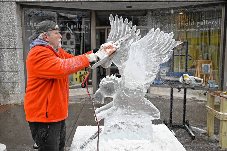Billy Poe of Three Rivers carves an eagle out of ice on Main Street in Greenfield.