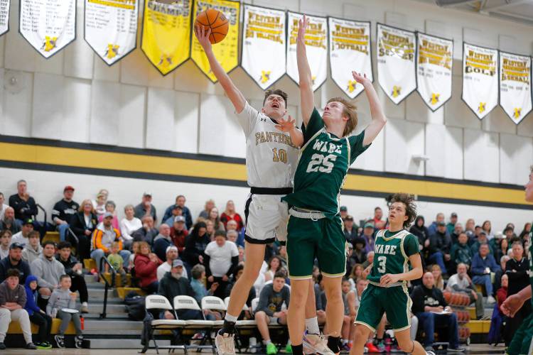 Pioneer’s Brayden Thayer (10) drives the ball to the hoop against Ware defender Justin Grout (25) in the third quarter of the MIAA Division 5 quarterfinal Friday night in Northfield.