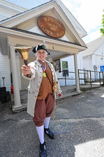 Kathy-Ann Becker, the town crier in Wendell, stands outside Town Hall.