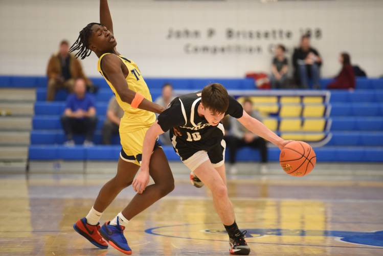 Pioneers Brayden Thayer dribbles around a New Mission defender in the MIAA Division 5 boys basketball state semifinal game at Worcester State University last year.  