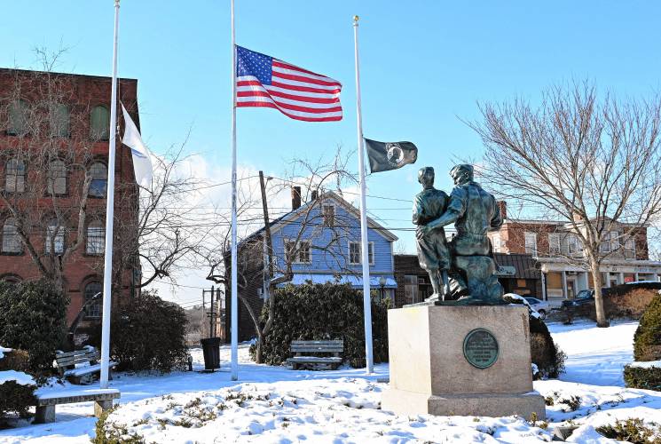 The Massachusetts Peace Statue and flagpoles in Memorial Park in the center of Orange.