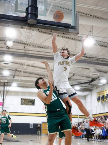 Pioneer’s Kurt Redeker (3) goes in for a layup over Ware defender Noah Perry (50) in the fourth quarter of the MIAA Division 5 quarterfinal Friday night in Northfield.