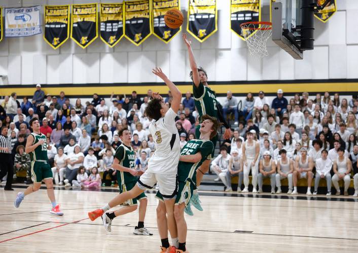 Pioneer’s Kurt Redeker (3) drives to the hoop over Ware defender Justin Grout (25) in the fourth quarter of the MIAA Division 5 quarterfinal Friday night in Northfield.