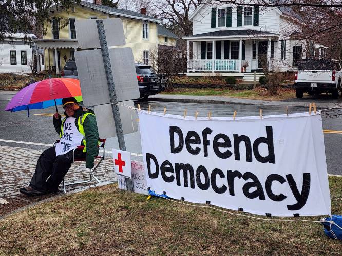 Conway resident Mary McClintock with a “Defend Democracy” banner made by Ann Gibson during Saturday’s “Hands Off!” protest along Route 116 in Conway. McClintock says, “We stand for democracy. We stand with millions of Americans to call for a stop to the illegal destruction of our government and our economy by Trump, his billionaire allies and the Republican administration. We say ‘Hands Off!’ the many programs paid for by our tax dollars — health care, education, veterans’ services, libraries, Social Security, SNAP, support for seniors and people with disabilities, and more. This is a crisis, and the time to act is now.”